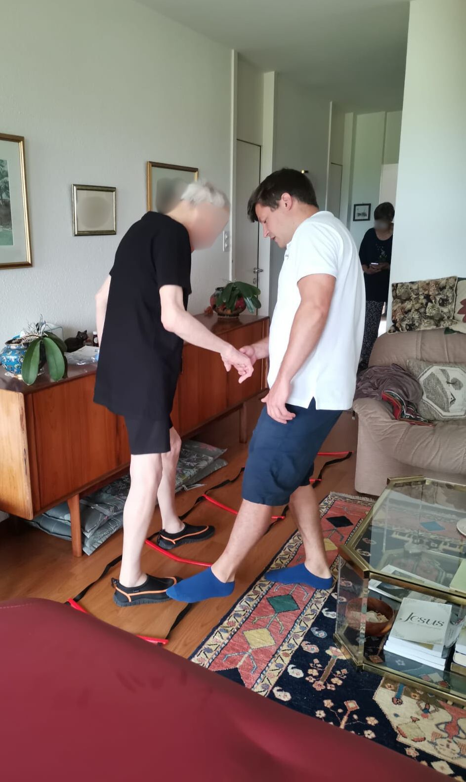 Enguerran Puche accompagne une patiente âgée lors d’un exercice de marche à son domicile